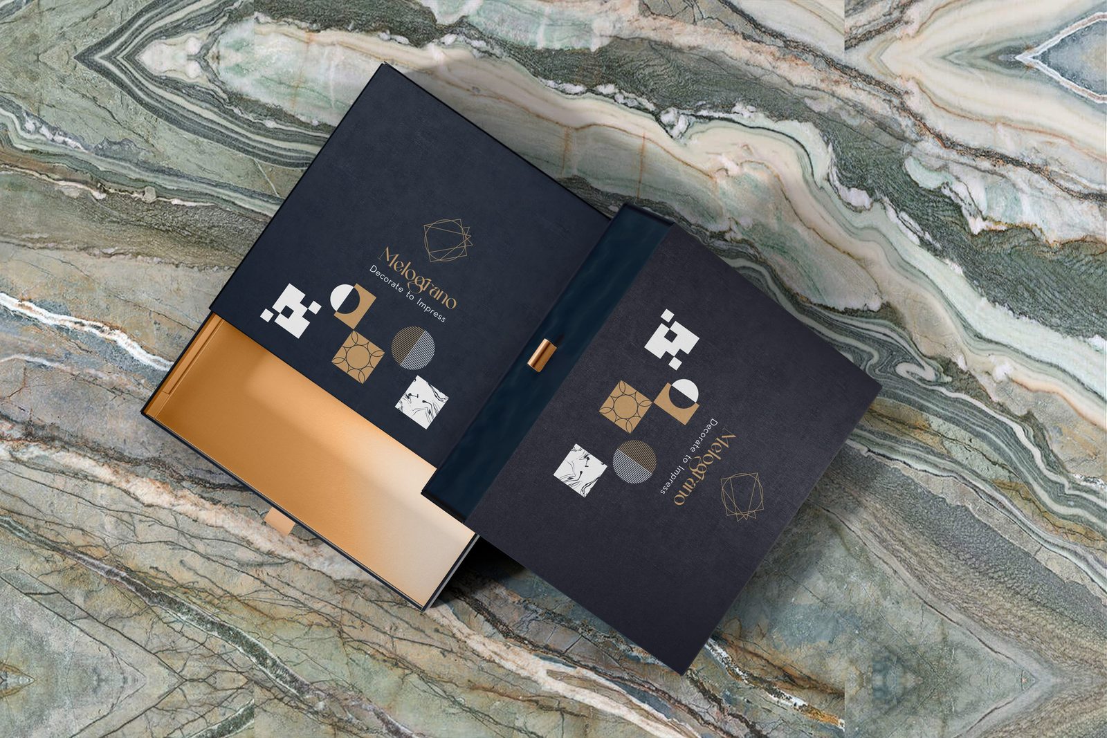 Box und Tragetasche von Melograno Stones in Navy und Gold auf grünem Marmor