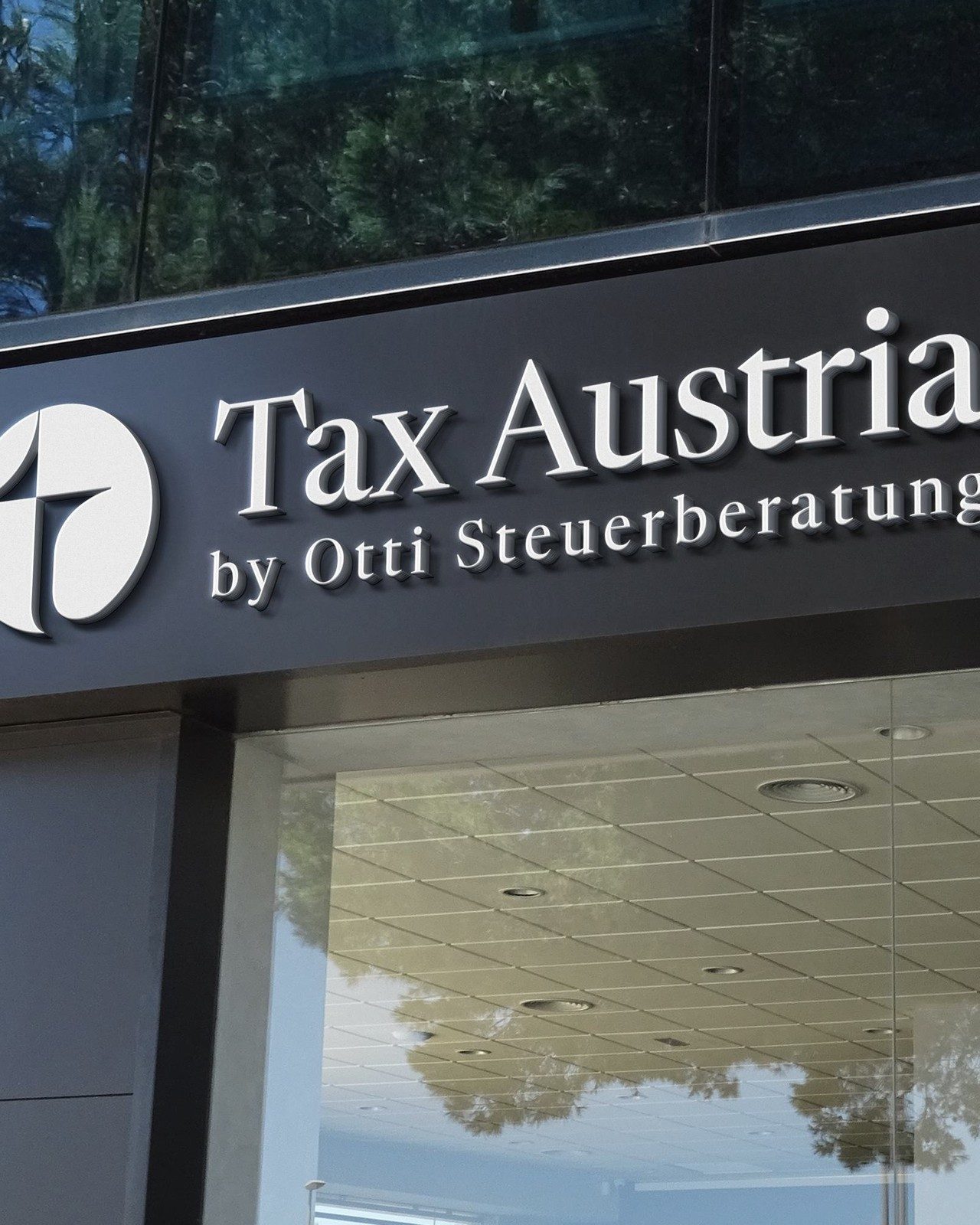 Schild „Tax Austria by Otti Steuerberatung“ über einem Eingang mit Glasfassade